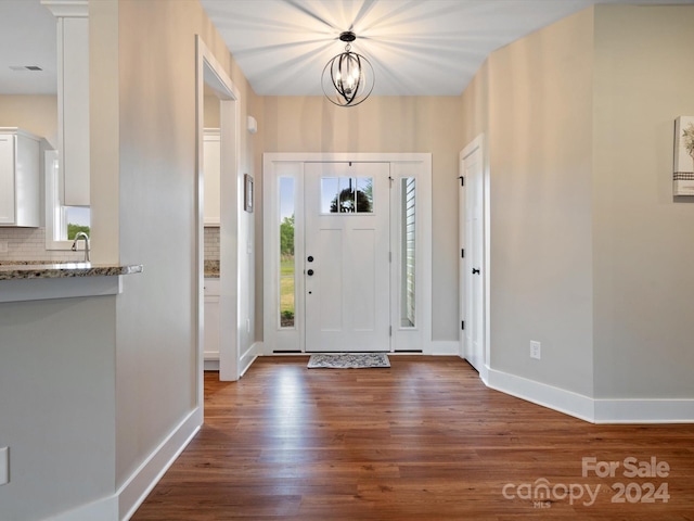 foyer featuring dark hardwood / wood-style flooring and a notable chandelier