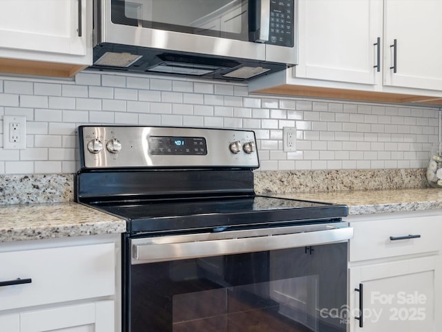 kitchen featuring stainless steel appliances, tasteful backsplash, and white cabinets