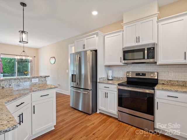 kitchen with white cabinetry, appliances with stainless steel finishes, tasteful backsplash, and pendant lighting