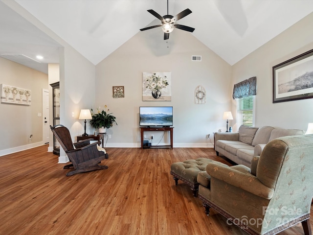 living room featuring hardwood / wood-style floors, vaulted ceiling, and ceiling fan