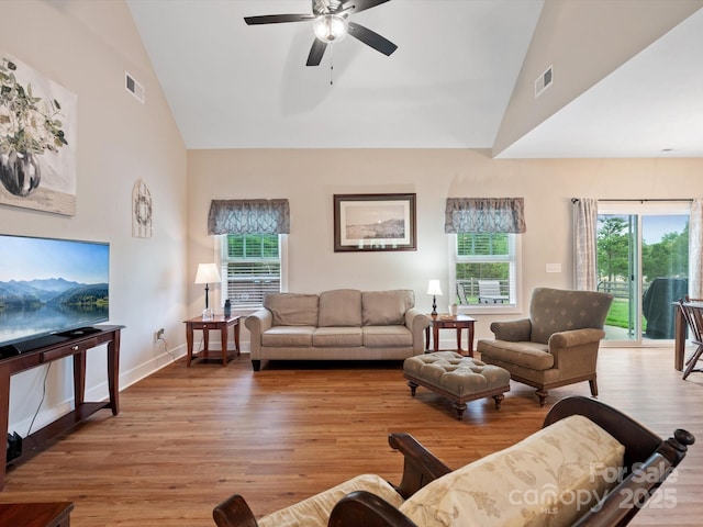 living room featuring high vaulted ceiling, ceiling fan, and light wood-type flooring