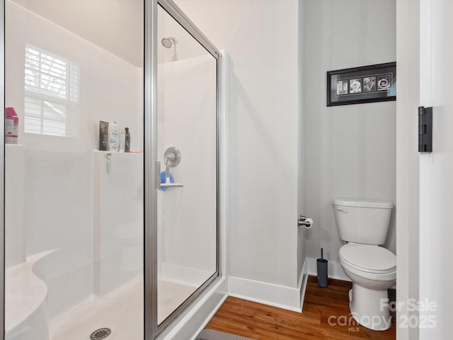 bathroom with an enclosed shower, hardwood / wood-style floors, and toilet