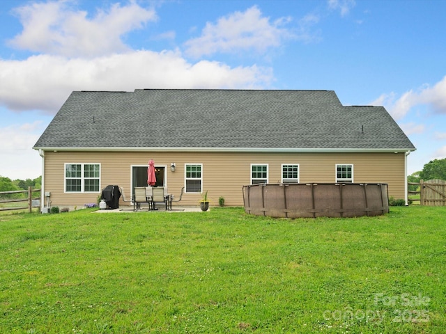 rear view of property featuring a patio and a lawn