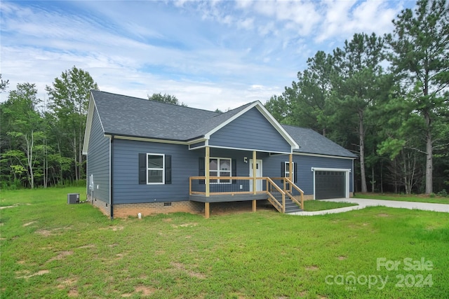 ranch-style home featuring a garage, a front yard, covered porch, and cooling unit