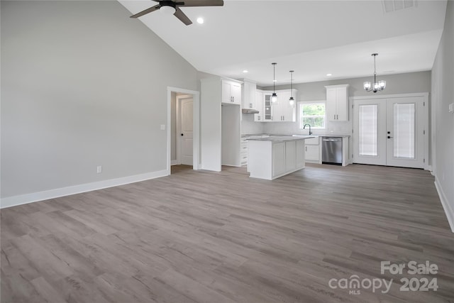 unfurnished living room with sink, light hardwood / wood-style flooring, high vaulted ceiling, ceiling fan with notable chandelier, and french doors