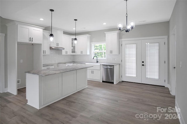 kitchen with stainless steel dishwasher, white cabinets, and decorative light fixtures