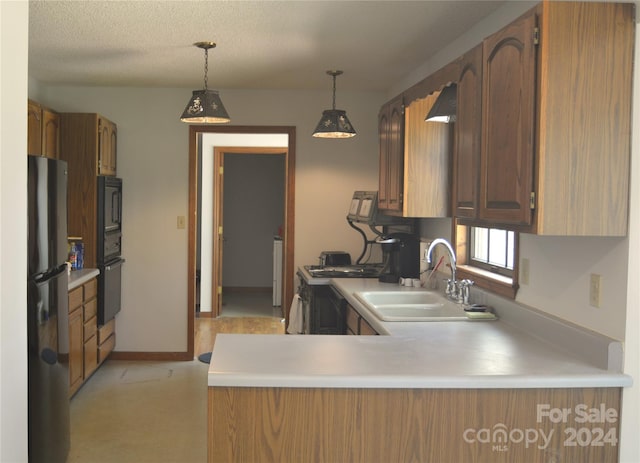 kitchen with kitchen peninsula, hanging light fixtures, wall oven, stainless steel fridge, and sink