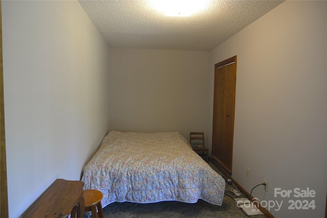 carpeted bedroom featuring a textured ceiling