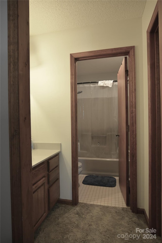 full bathroom with toilet, a textured ceiling, vanity, bathtub / shower combination, and tile floors