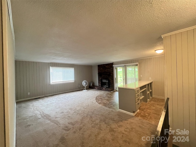 unfurnished living room featuring a healthy amount of sunlight, carpet, and a fireplace