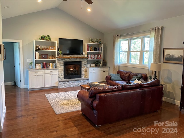 living room featuring ceiling fan, dark hardwood / wood-style floors, vaulted ceiling, and a fireplace