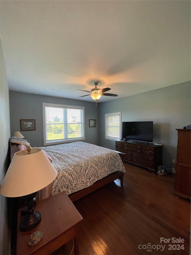 bedroom with dark hardwood / wood-style floors and ceiling fan