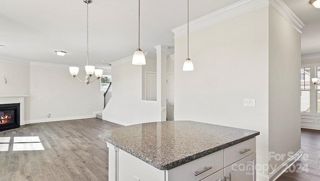 kitchen featuring wood-type flooring, a wealth of natural light, white cabinetry, and hanging light fixtures