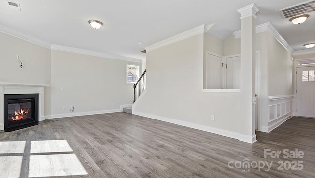 unfurnished living room featuring hardwood / wood-style flooring and crown molding