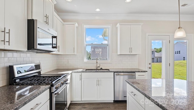 kitchen with white cabinetry, appliances with stainless steel finishes, sink, and dark stone countertops