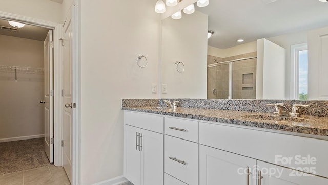 bathroom featuring tile patterned flooring, vanity, and an enclosed shower