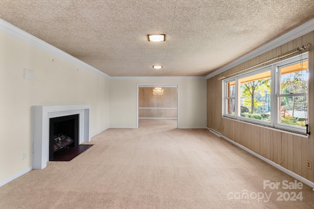 unfurnished living room with wooden walls, light colored carpet, a textured ceiling, and ornamental molding