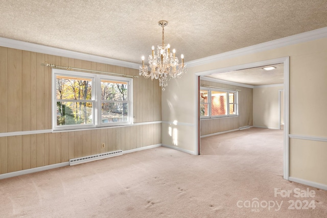 carpeted spare room featuring a baseboard heating unit, crown molding, a chandelier, a textured ceiling, and wooden walls