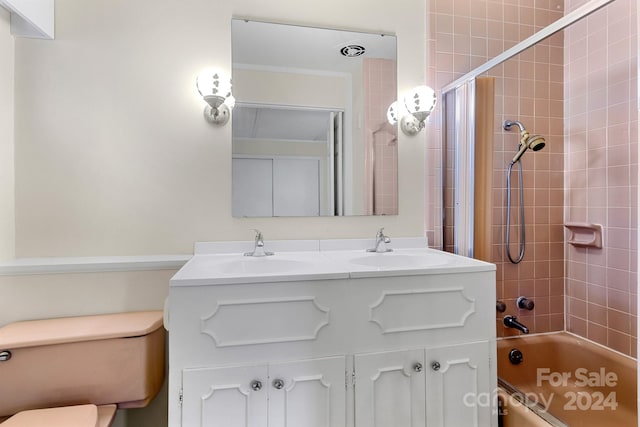 full bathroom featuring vanity, toilet, and tiled shower / bath