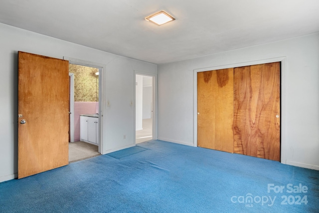 unfurnished bedroom with ensuite bath, a closet, and light colored carpet