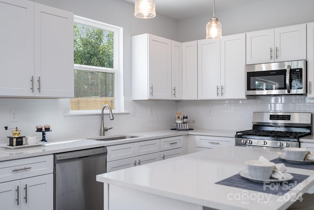 kitchen featuring stainless steel appliances, decorative backsplash, and white cabinets