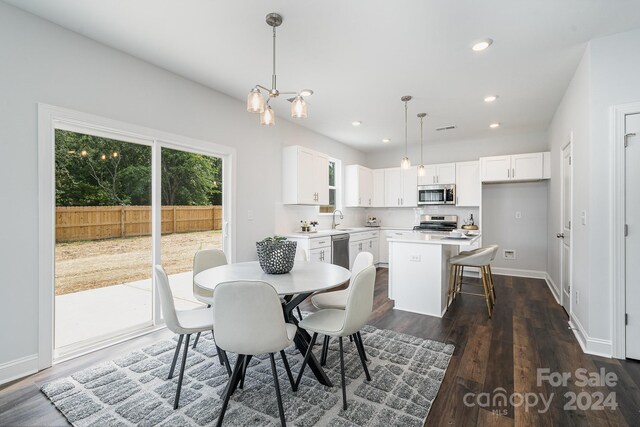 dining room with sink, dark wood-type flooring, and a chandelier