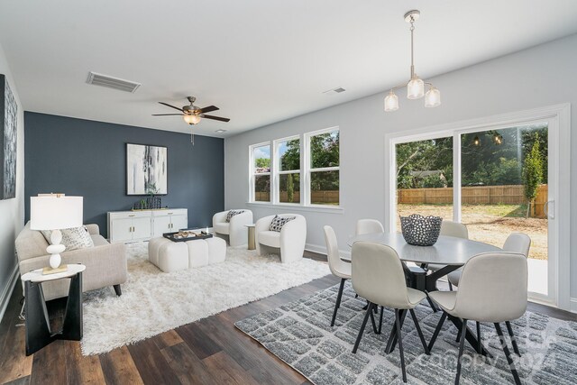 dining room with ceiling fan, a healthy amount of sunlight, and dark wood-type flooring