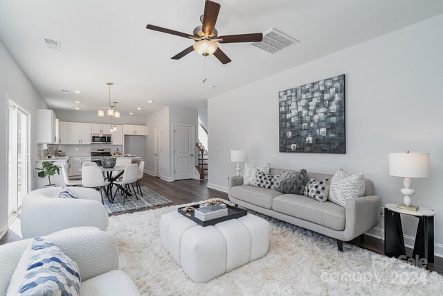 living room with sink, ceiling fan, and light wood-type flooring