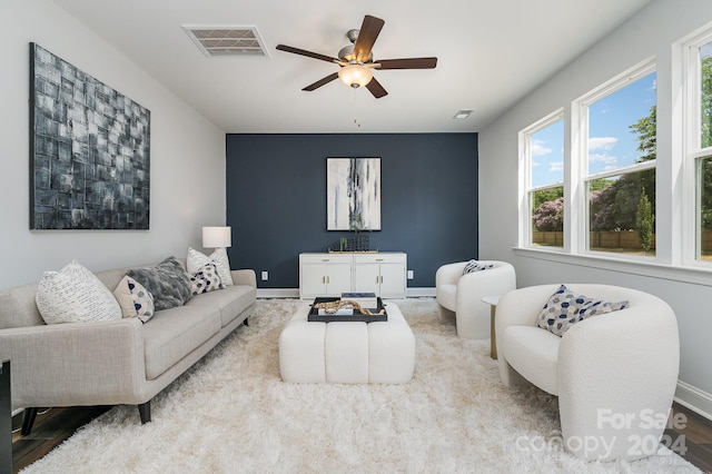 living room featuring ceiling fan, light wood-type flooring, and plenty of natural light