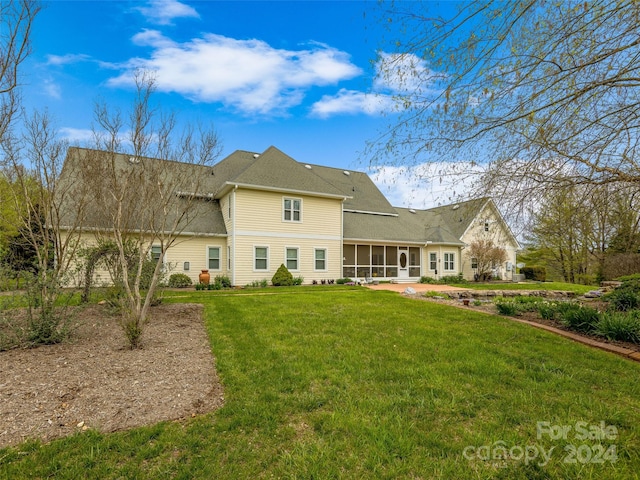 rear view of house featuring a sunroom, a patio area, and a yard