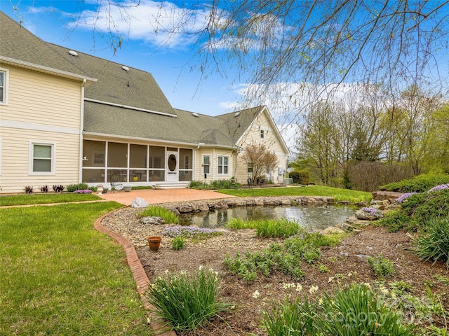 back of house featuring a sunroom and a yard