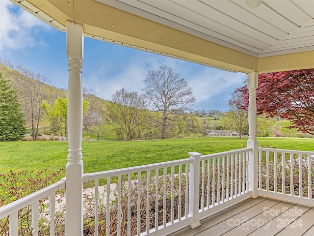 wooden deck with a lawn and covered porch