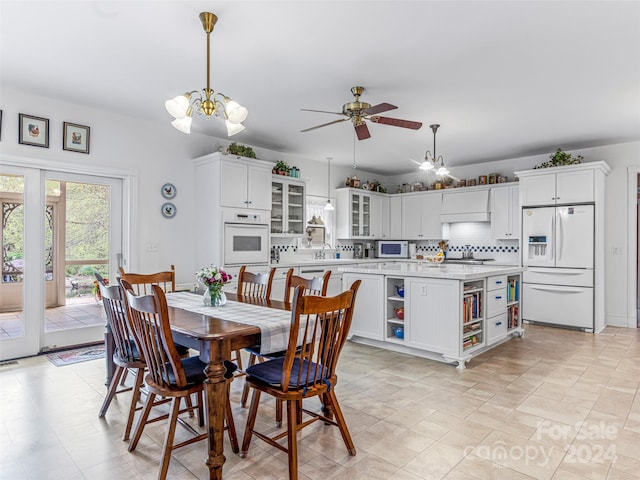 dining space featuring sink and ceiling fan with notable chandelier