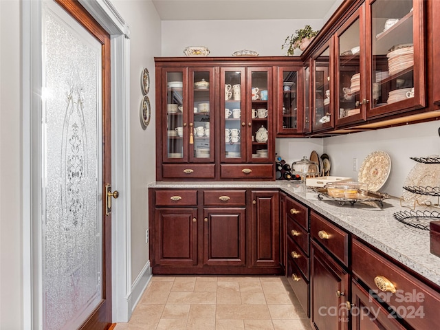 bar featuring light stone countertops and light tile patterned floors