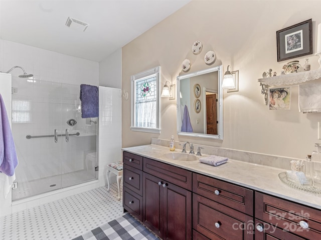 bathroom featuring a shower with door and vanity