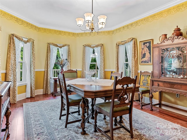 dining area featuring dark hardwood / wood-style floors, an inviting chandelier, and ornamental molding