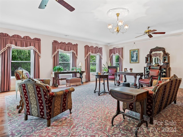 living room with ceiling fan with notable chandelier, light hardwood / wood-style flooring, and ornamental molding