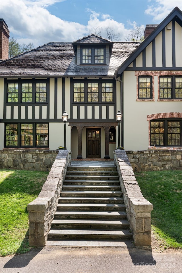 property entrance with covered porch and a lawn