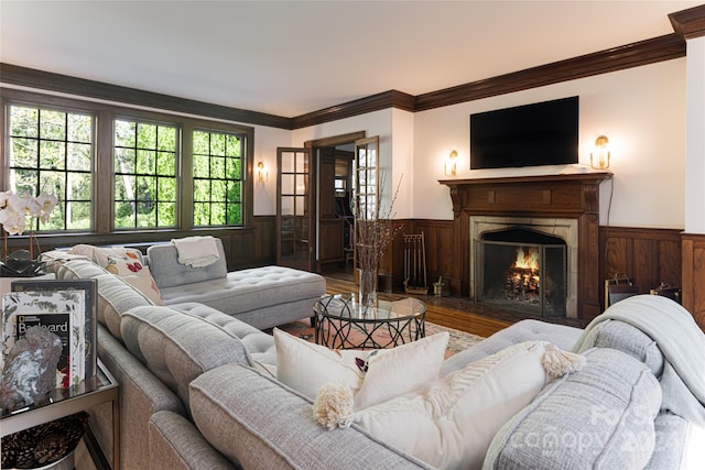 living room featuring wood walls, wood-type flooring, and ornamental molding