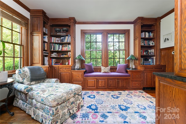 sitting room featuring dark hardwood / wood-style flooring, crown molding, and wood walls