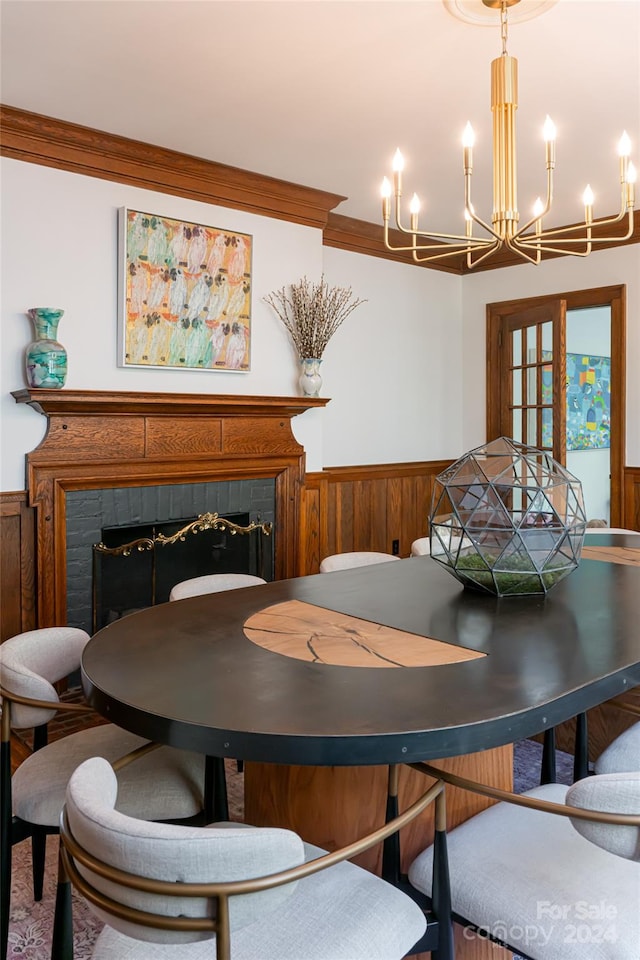 dining area featuring crown molding, wooden walls, and an inviting chandelier