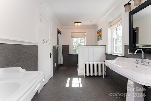 bathroom with crown molding, radiator heating unit, and tile walls