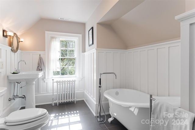 bathroom featuring radiator, tile patterned flooring, a bathtub, and vaulted ceiling