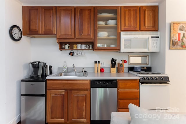 kitchen with sink, ornamental molding, and stainless steel appliances