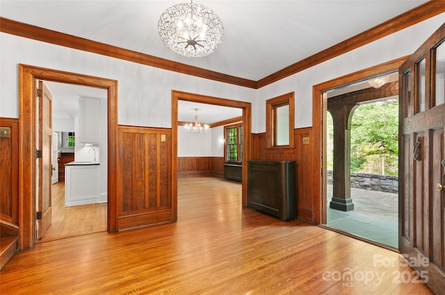 30 Cedarcliff Rd, Asheville, NC 28803 - foyer with a chandelier, a wainscoted wall, light wood-style flooring, ornamental molding, and wooden walls