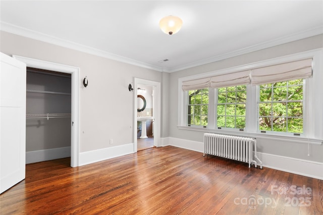 30 Cedarcliff Rd, Asheville, NC 28803 - unfurnished living room with radiator heating unit, ornamental molding, wood finished floors, and baseboards