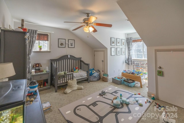 bedroom with carpet floors, ceiling fan, a crib, and multiple windows