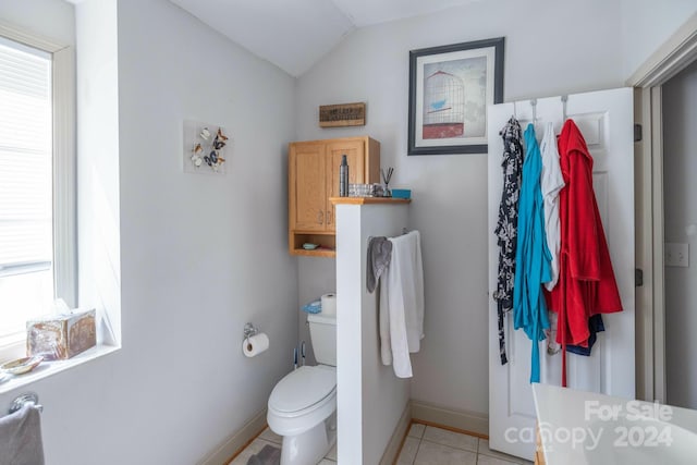 bathroom with toilet, tile flooring, and vaulted ceiling