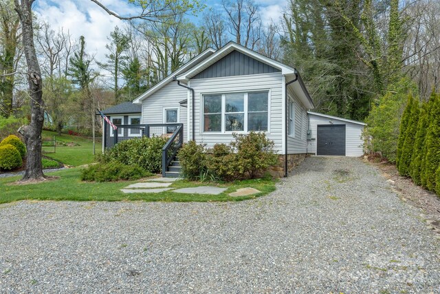 view of front of property with a garage, a front yard, and an outdoor structure