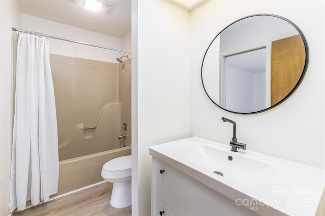 full bathroom featuring hardwood / wood-style flooring, vanity, shower / bathtub combination with curtain, and toilet